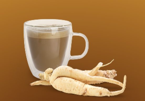 Kaffeetasse mit braunem Getränk und getrockneten Wurzelstücken daneben.