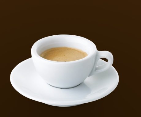 Eine kleine Tasse Espresso auf einer weißen Untertasse.
