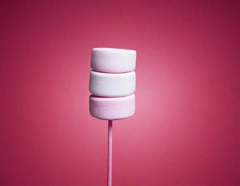 Marshmallow in Rosa und Weiß vor einem pinken Hintergrund.